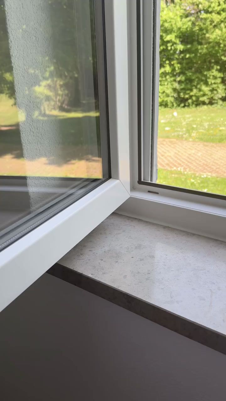 Gereinigtes weißes Kunststofffenster mit sauberem Rahmen und heller Fensterbank